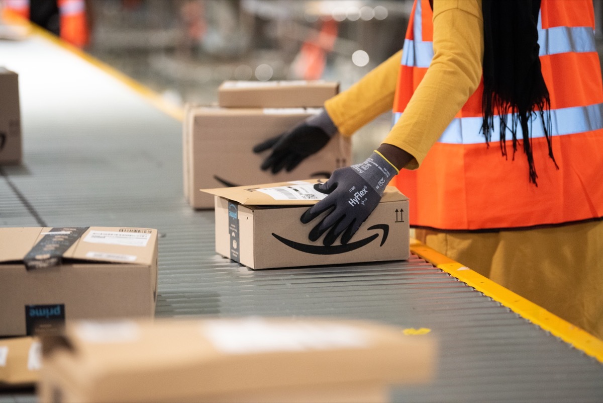 Amazon worker handling package in warehouse