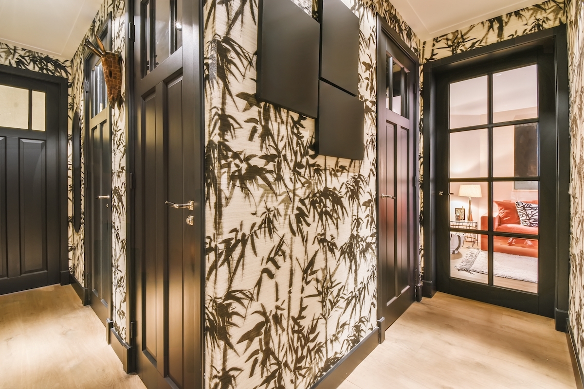 An entry hall with black-and-white printed wallpaper and black trim