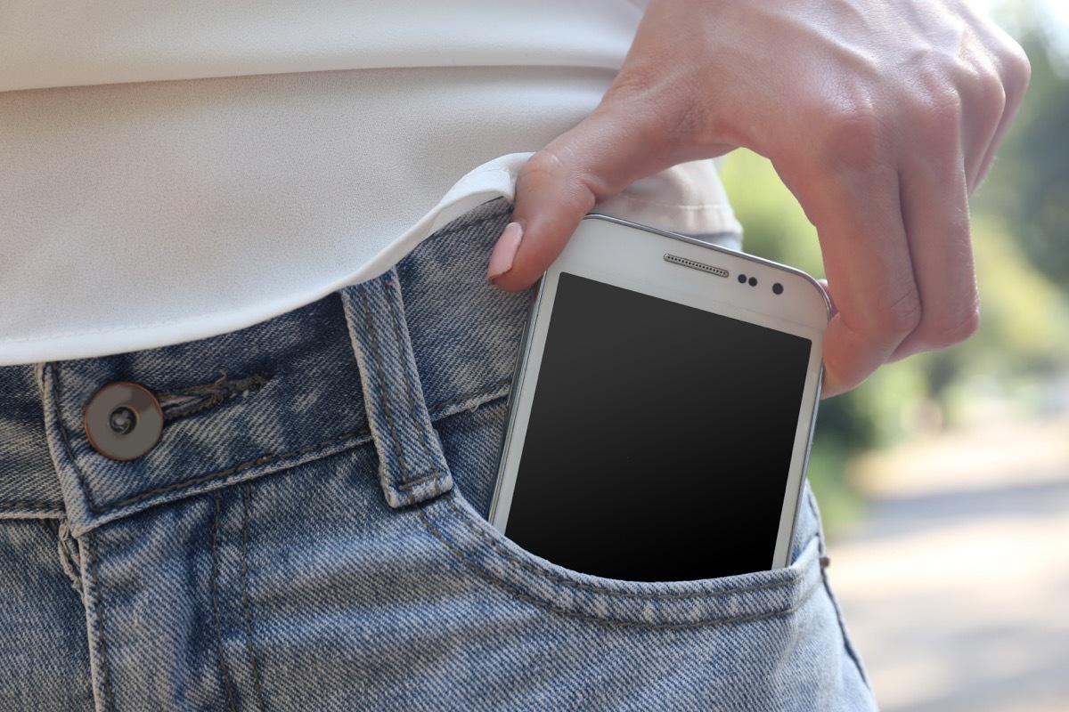 Person putting their phone in their jeans pocket