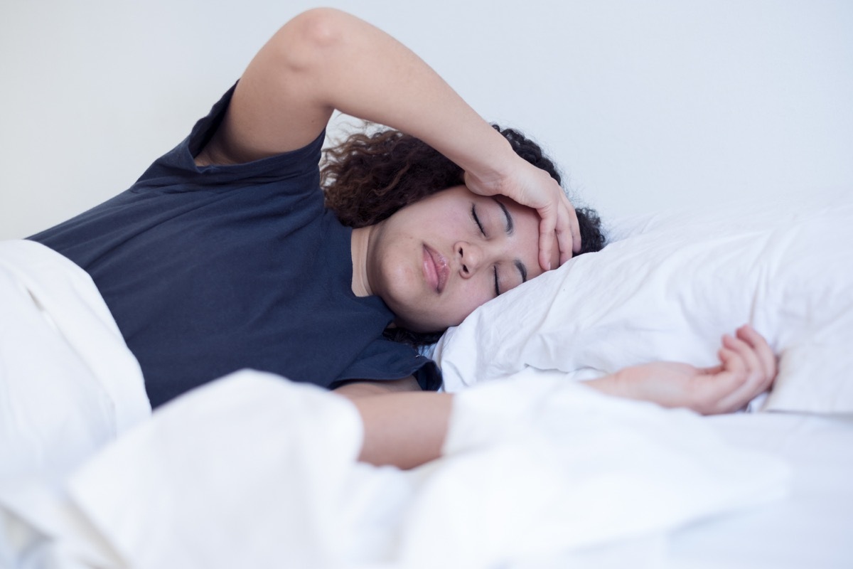 Sick and tired woman lying in the bed