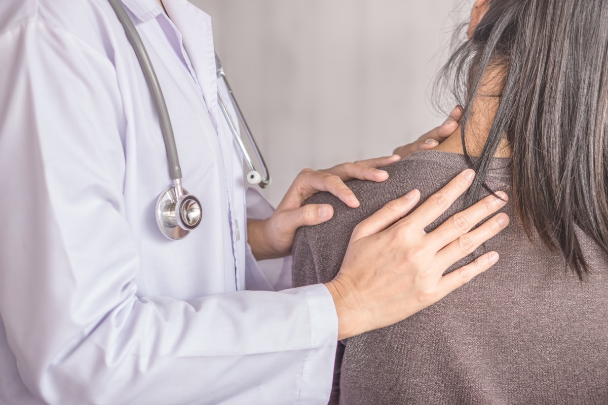 female doctor examining a patient suffering from neck and shoulder pain