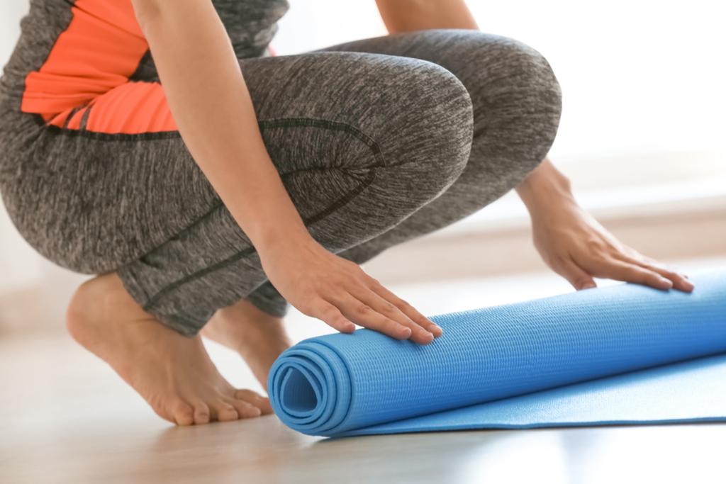 Woman Rolling Up Yoga Mat House Cleaning