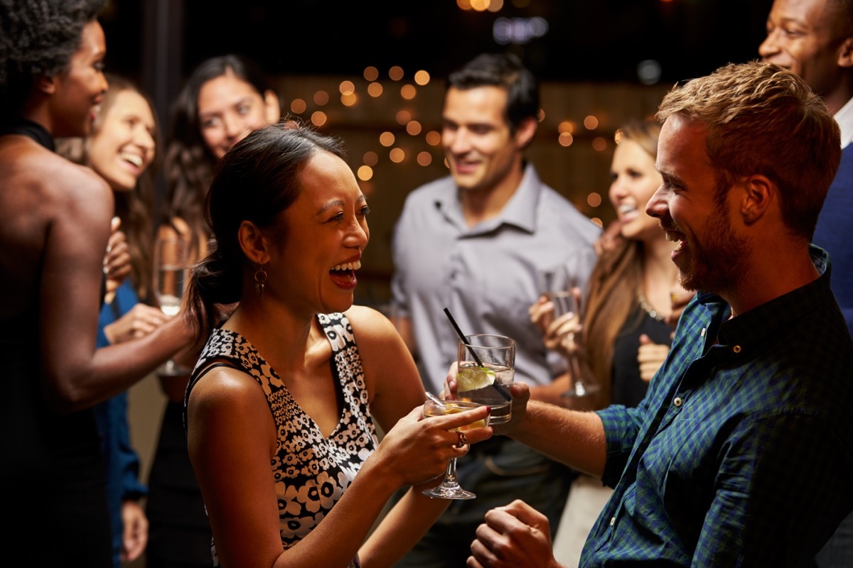 woman and man laughing in conversation at a cocktail party