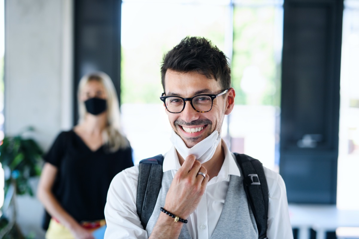 man with face mask back at work in office after lockdown