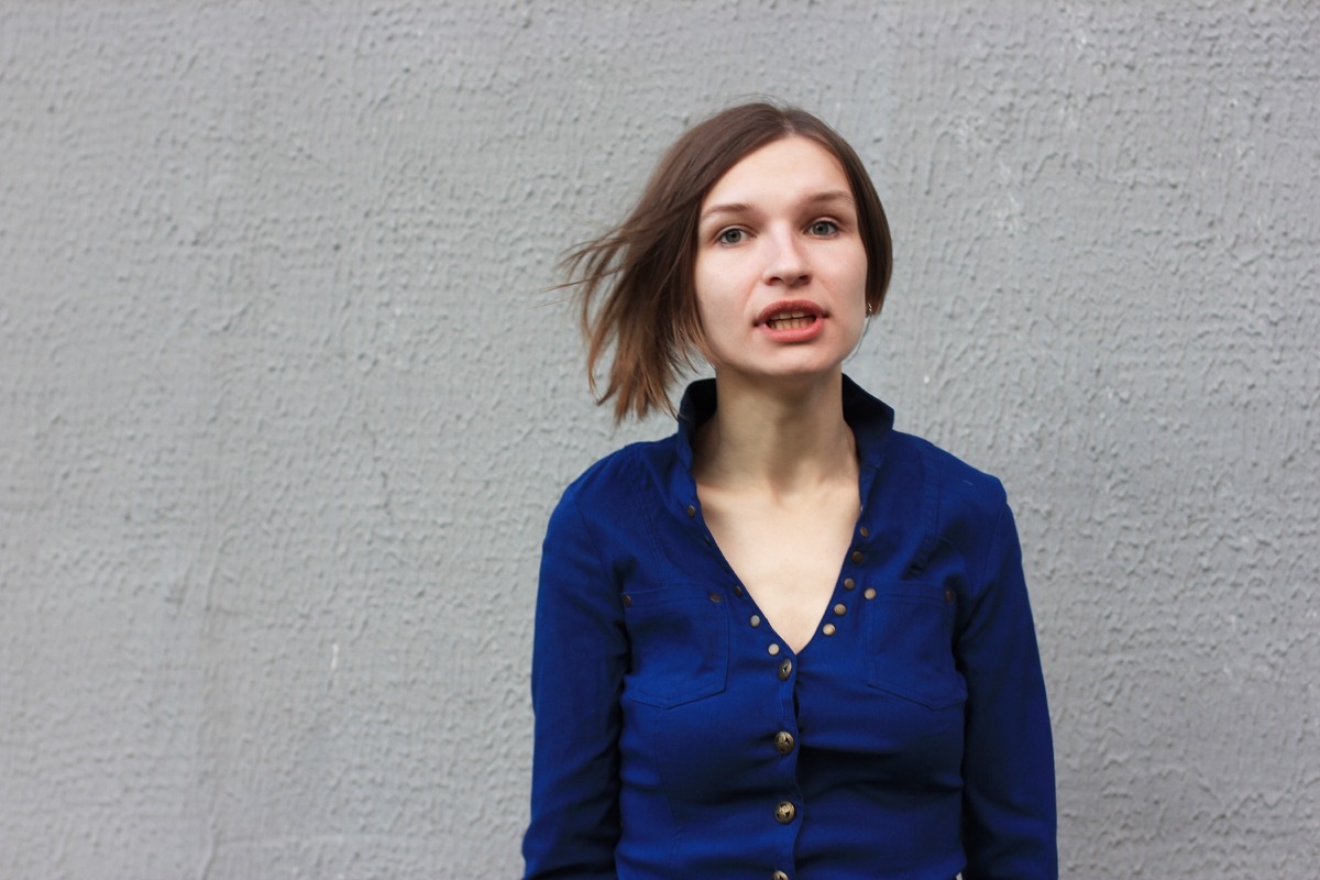 Woman in a blue shirt talking to herself.