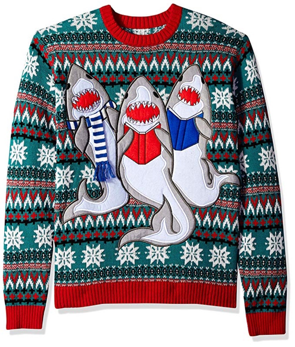 man wearing striped christmas sweater with three singing sharks in scarves on it