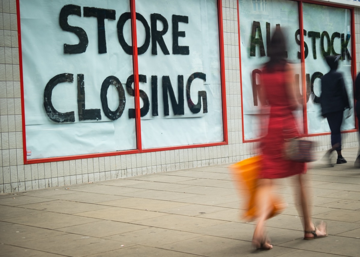 store closing sign with shopper walking past