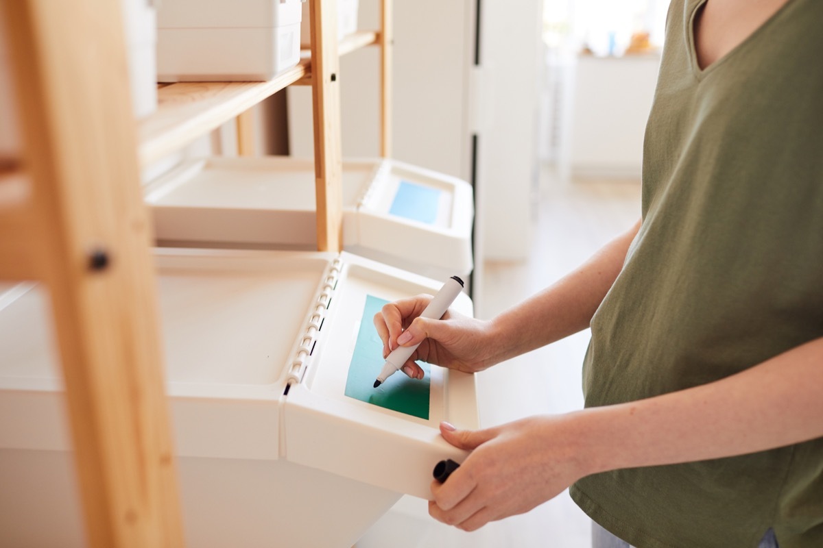 woman labeling plastic storage bin