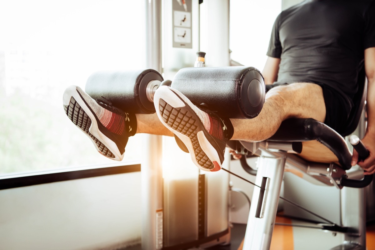 Man using the leg extension machine at the gym