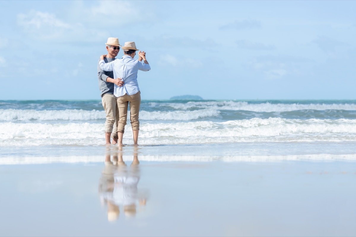 A couple dances on the beach together.