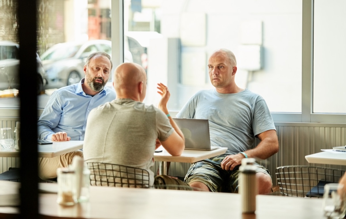 Group of friends sitting at cafe and talking