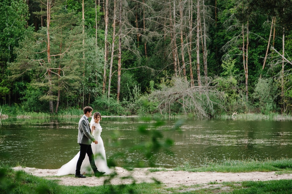 bride and groom walking through nature this is the age most people get married in every US state