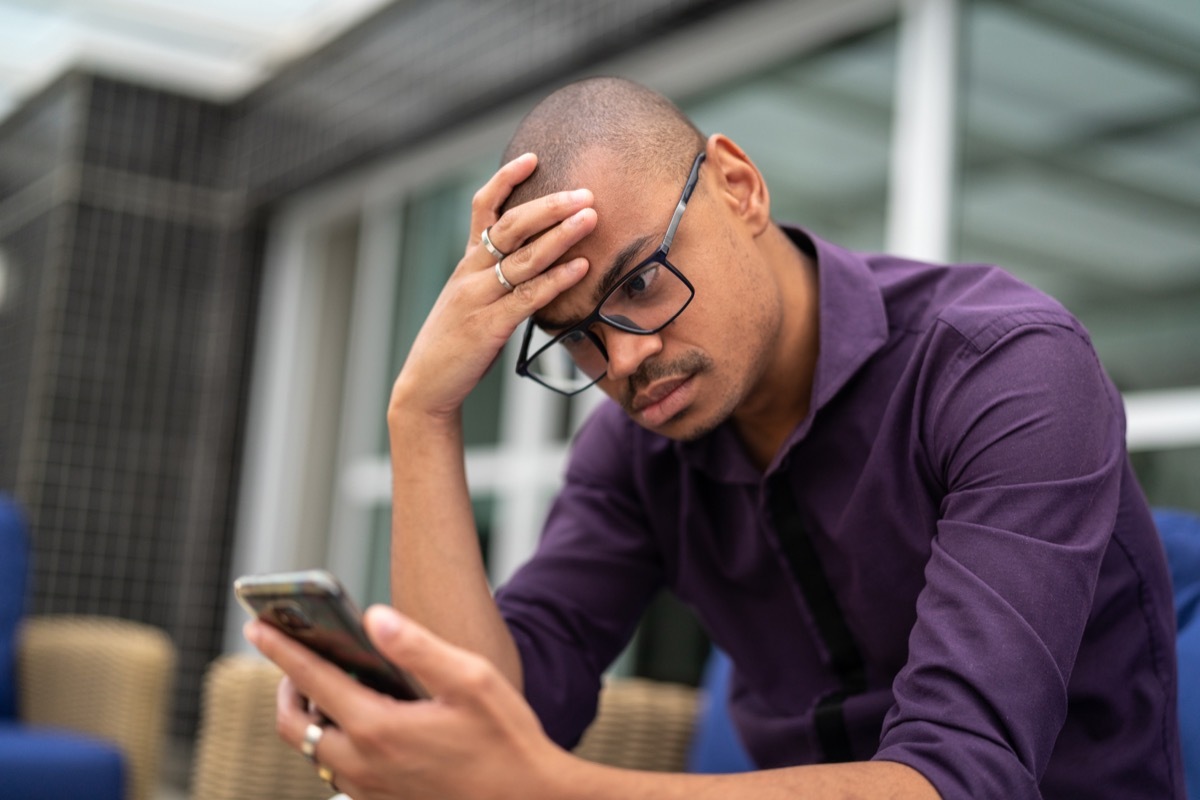 Businessman worried about the news on his mobile phone