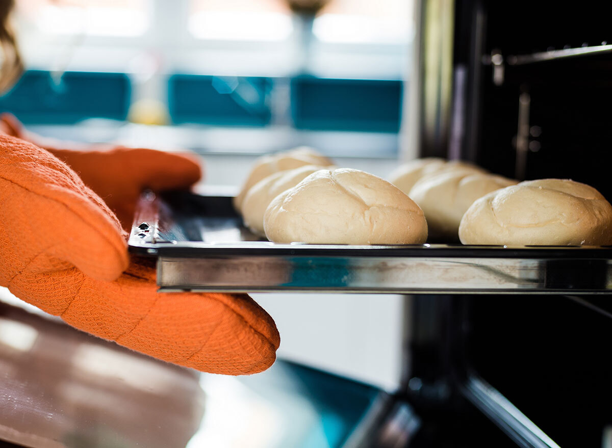 Gloves holding pan into oven