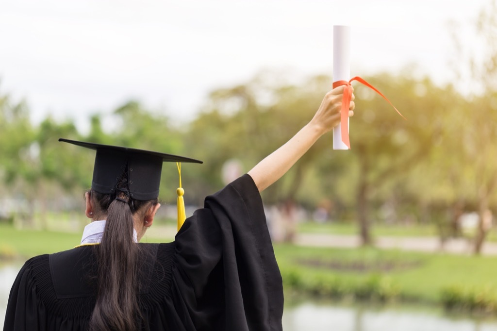 Woman holding up her college degree