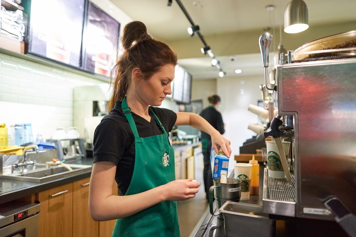 SAINT PETERSBURG, RUSSIA - MARCH 12, 2016: worker at Starbucks Cafe. Starbucks Corporation is an American global coffee company and coffeehouse chain based in Seattle, Washington