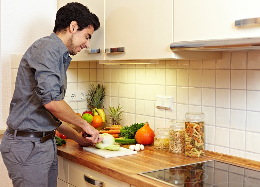 Man chopping vegetables in kitchen