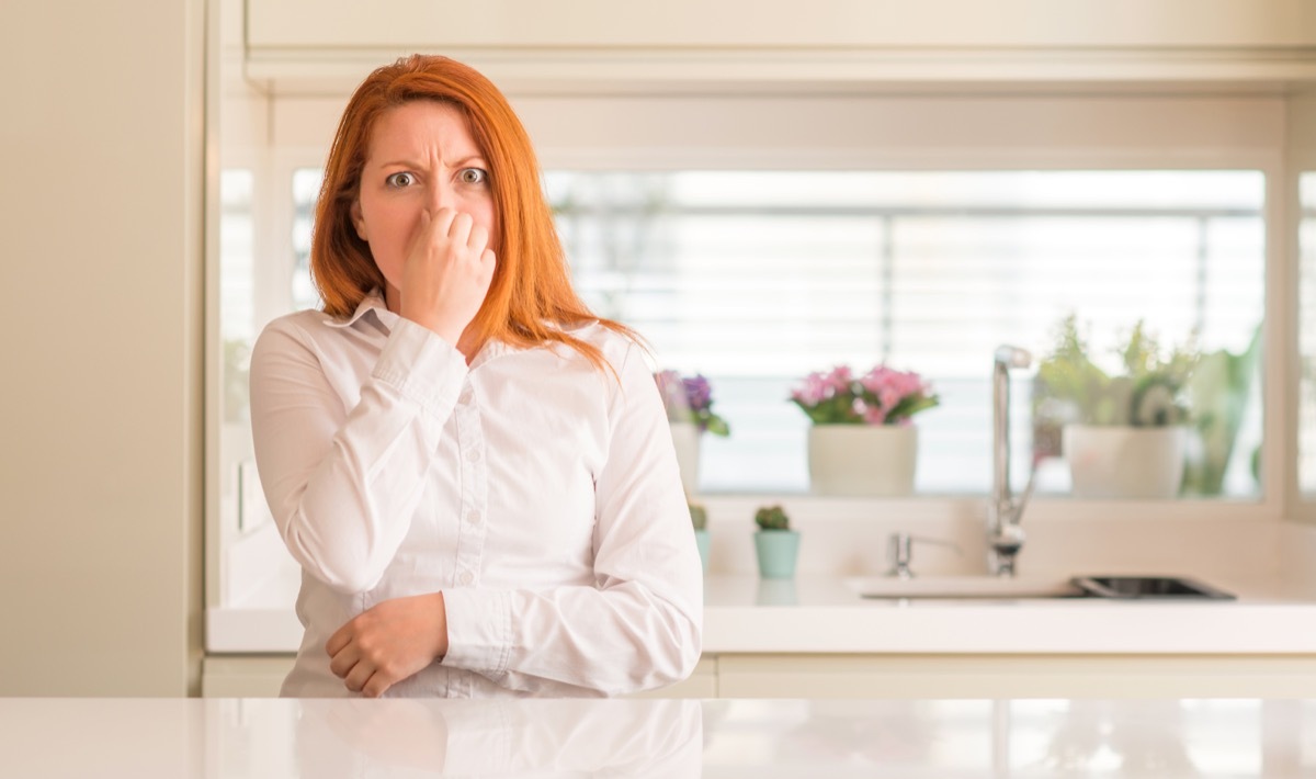 redheaded woman holding nose 