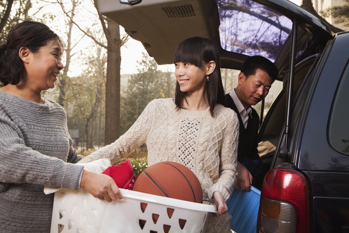 Family parents helping young daughter move Asian