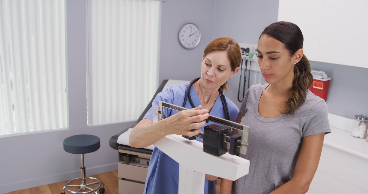 Woman getting weighed on a scale at the doctor's office