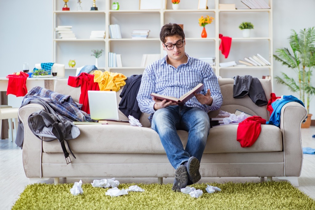 man sitting in messy living room