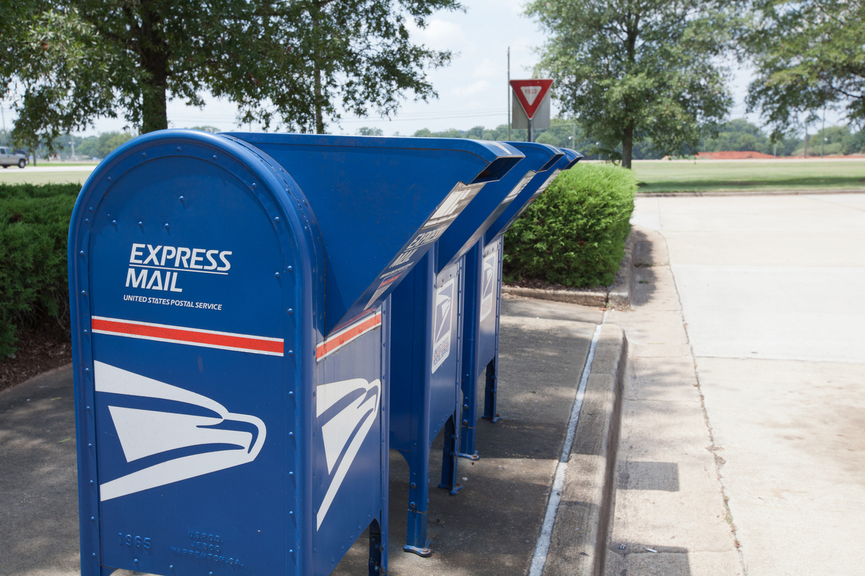 A trio of blue express mail mailboxes on a street