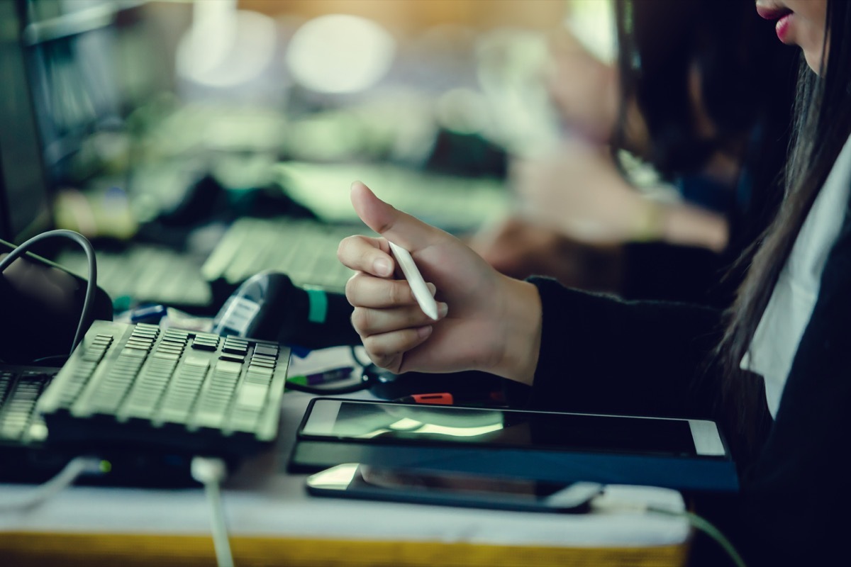 asian woman using stylus to sign tablet