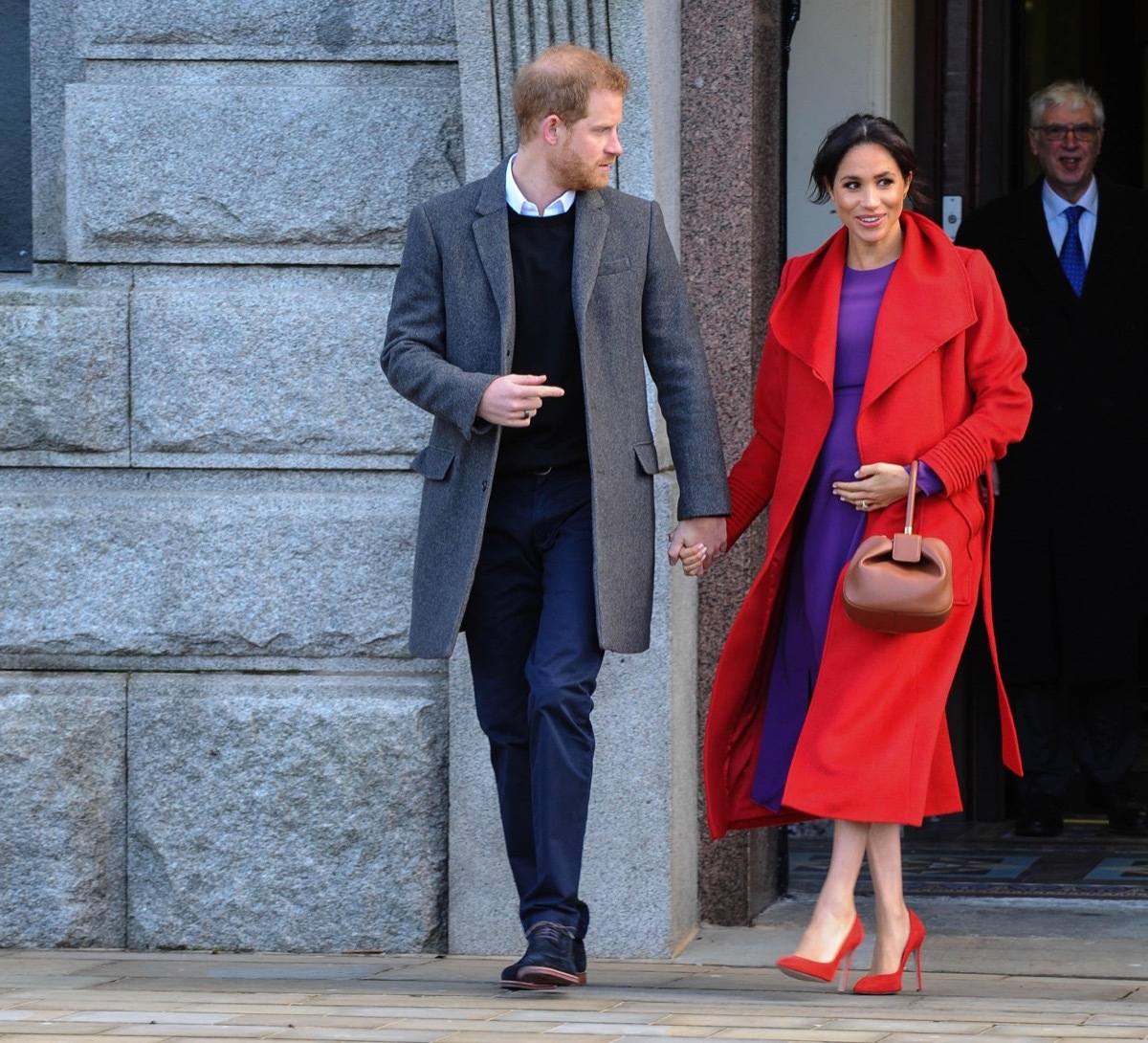 prince harry looking concerned while holding hands with meghan markle