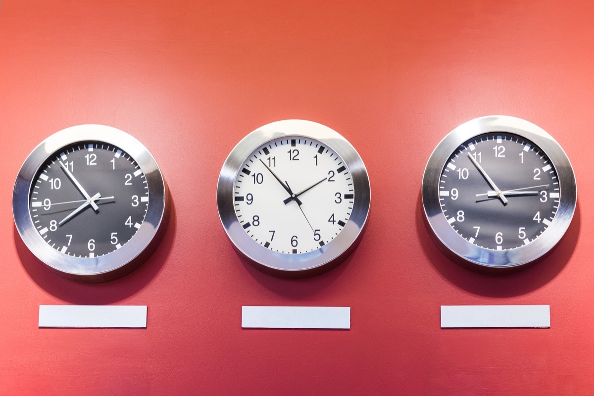 Three clocks on wall showing different time zones