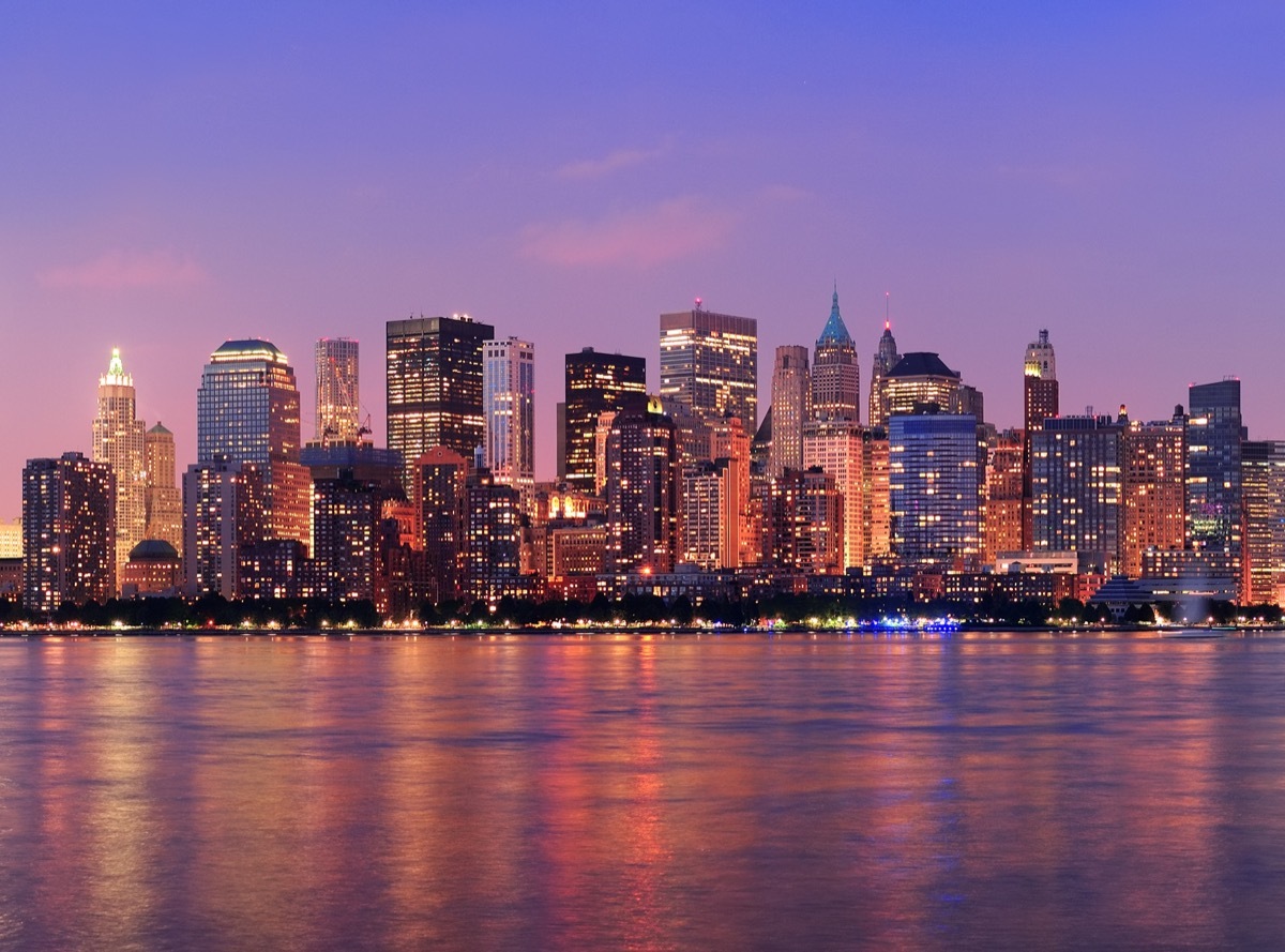 city skyline and skyscrapers along the Hudson River in New York, New York at sunset