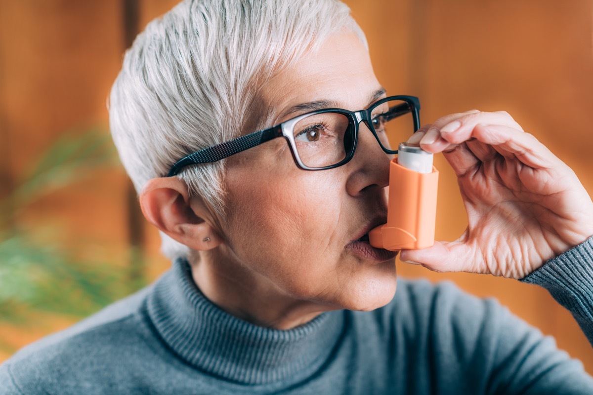 Woman taking puff of inhaler