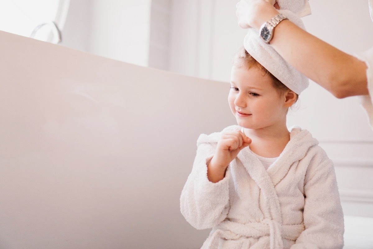 kid in white bathrobe with towel on hair