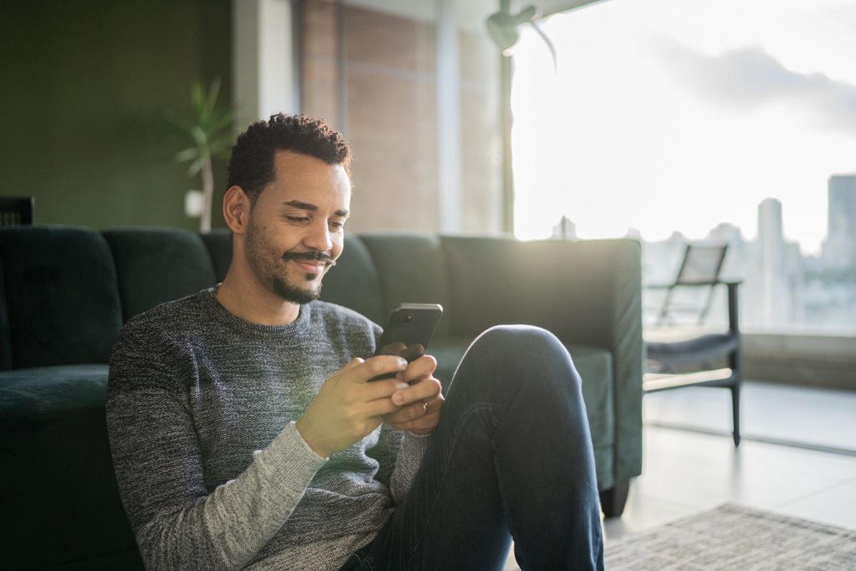 Man using smartphone at home