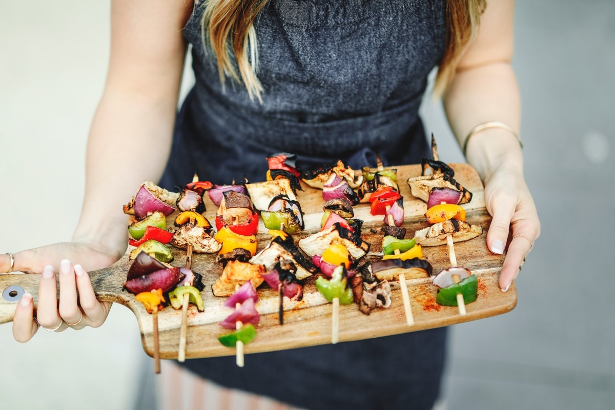 Woman Serving BBQ Vegetable Skewers BBQ Etiquette Mistakes