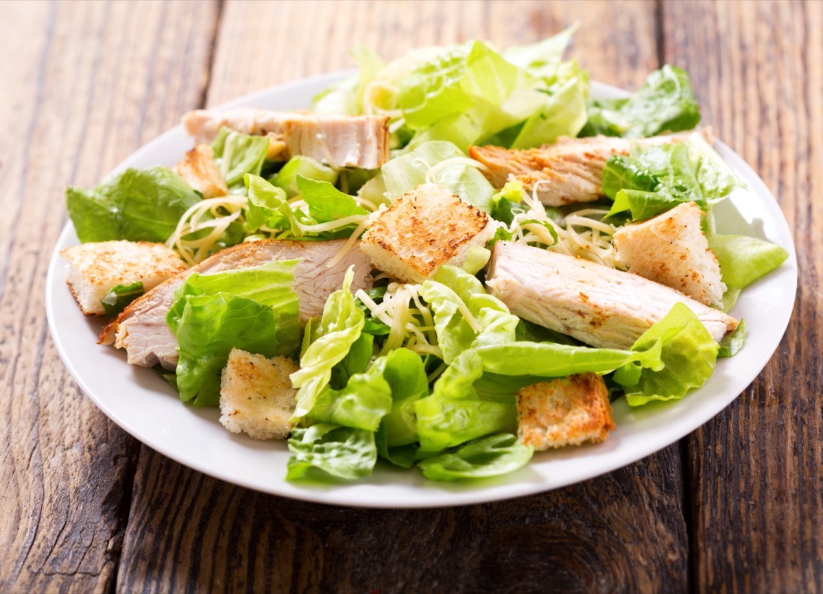 chicken caesar salad in white bowl