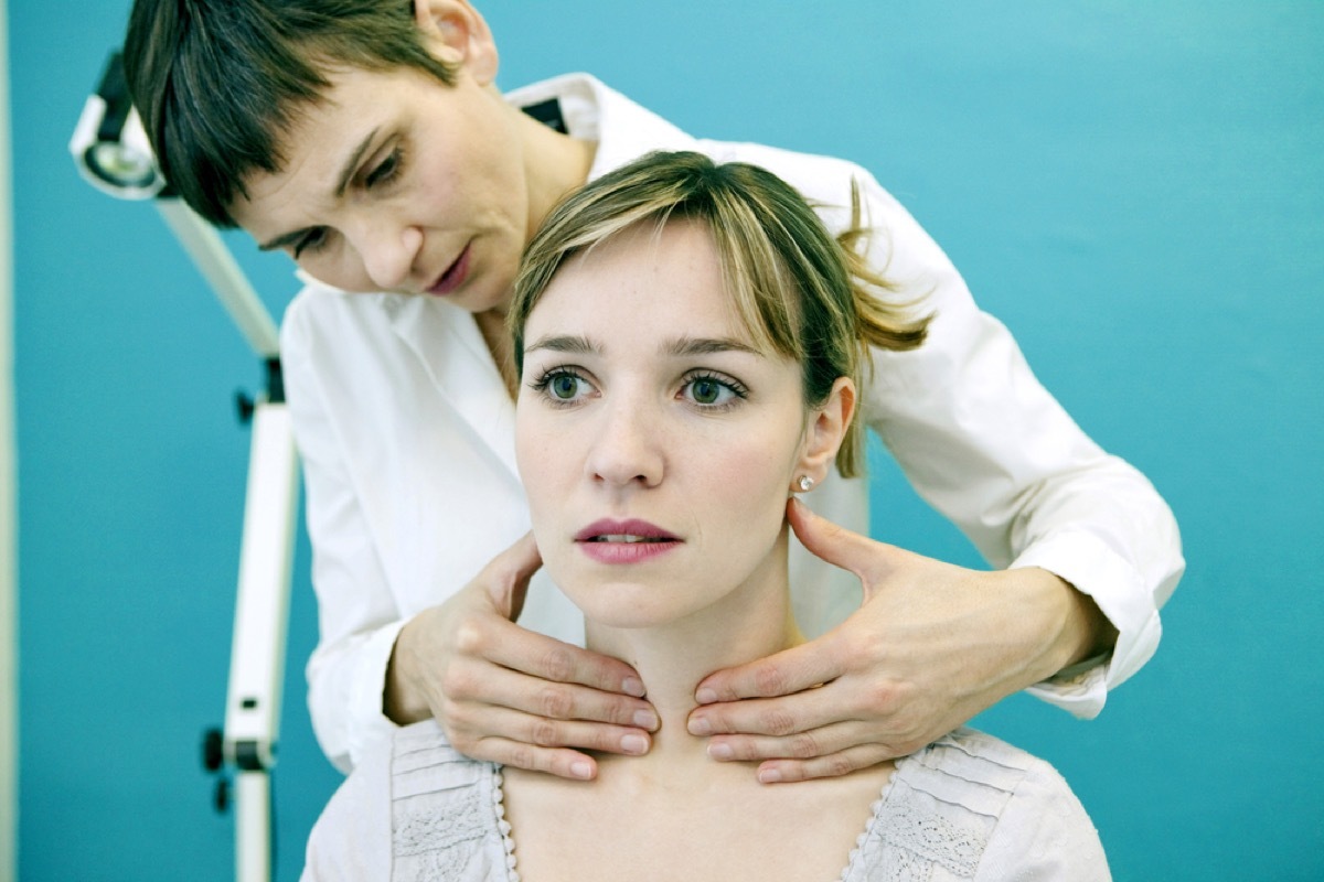 young white woman having thyroid checked by female doctor