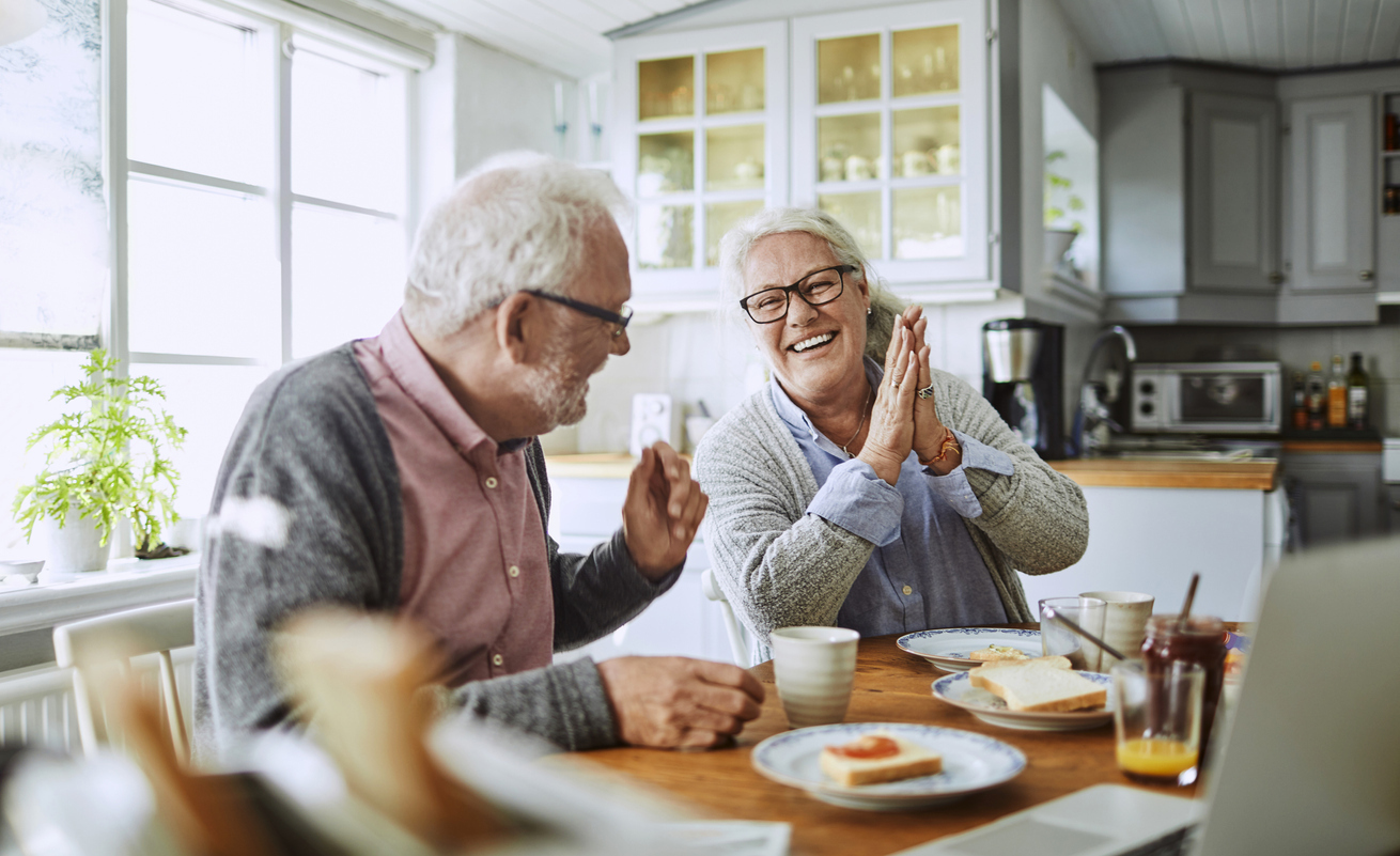 A senior couple eating breakfast and smiling