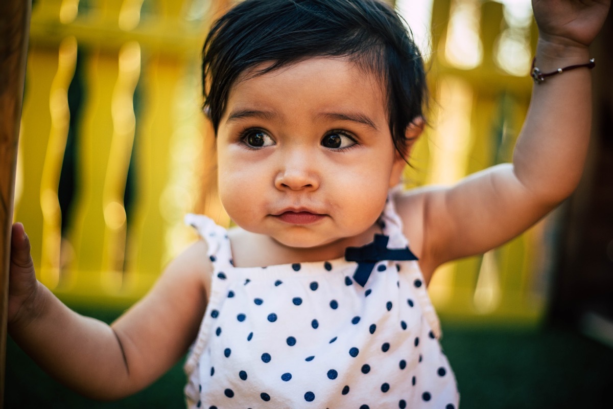 girl baby playing outside looking around