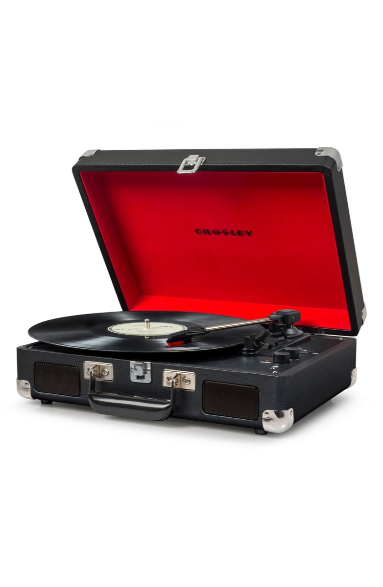 record playing on turntable in black case with red interior