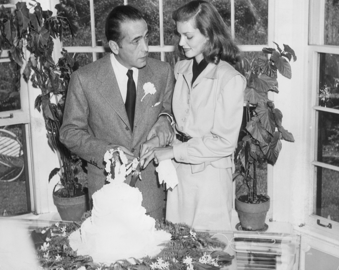 Humphrey Bogart and Lauren Bacall cutting their wedding cake in 1945