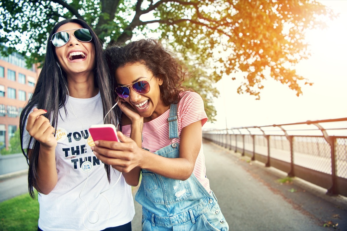 two friends looking at their phones laughing at dirty pickup lines