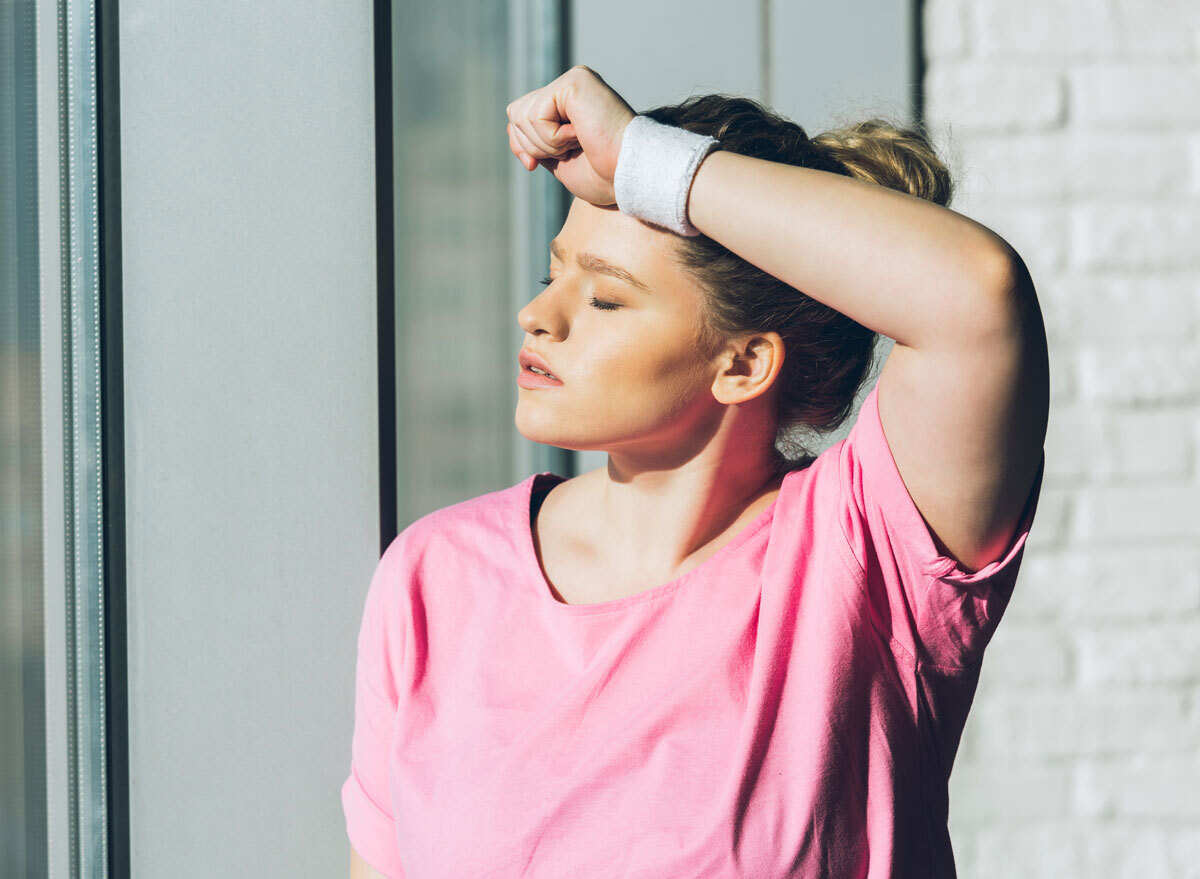 Tired woman exercising in pink shirt