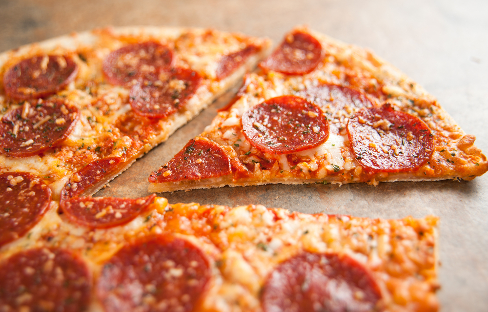 A close up of a piece of pepperoni pizza