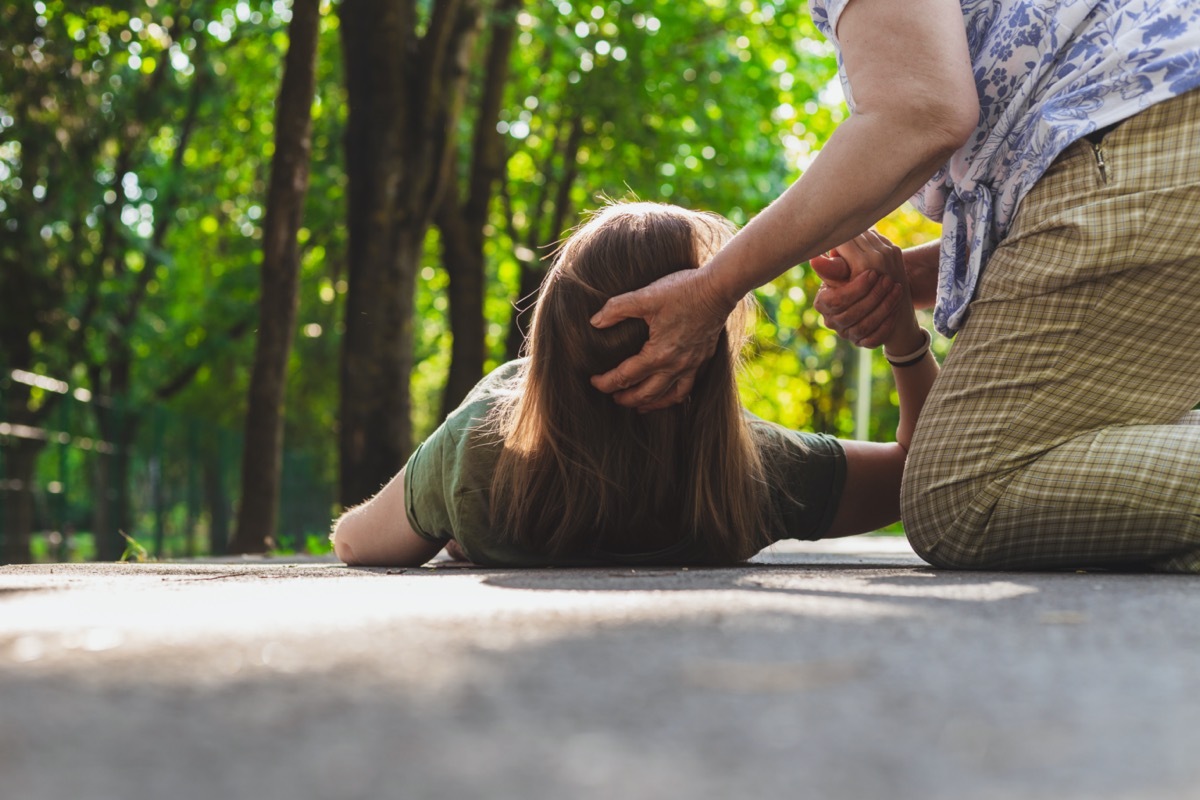 Teenager trying to get back on her feet while receiving support from an elder