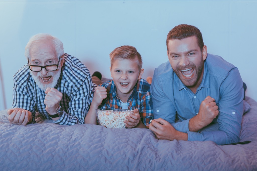 grandfather father and son watching a movie