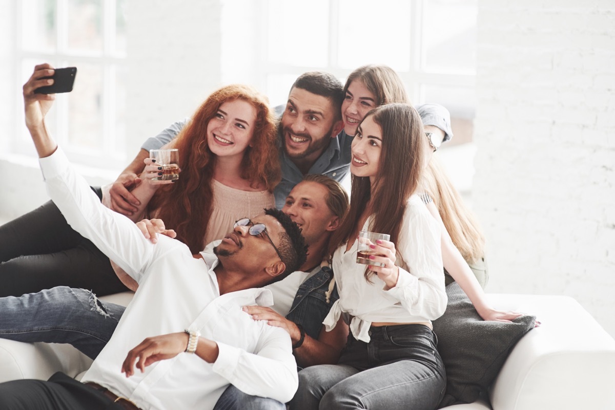 little alcohol will not be superfluous. Group of multiracial teammates having good time on their break and taking some photos.