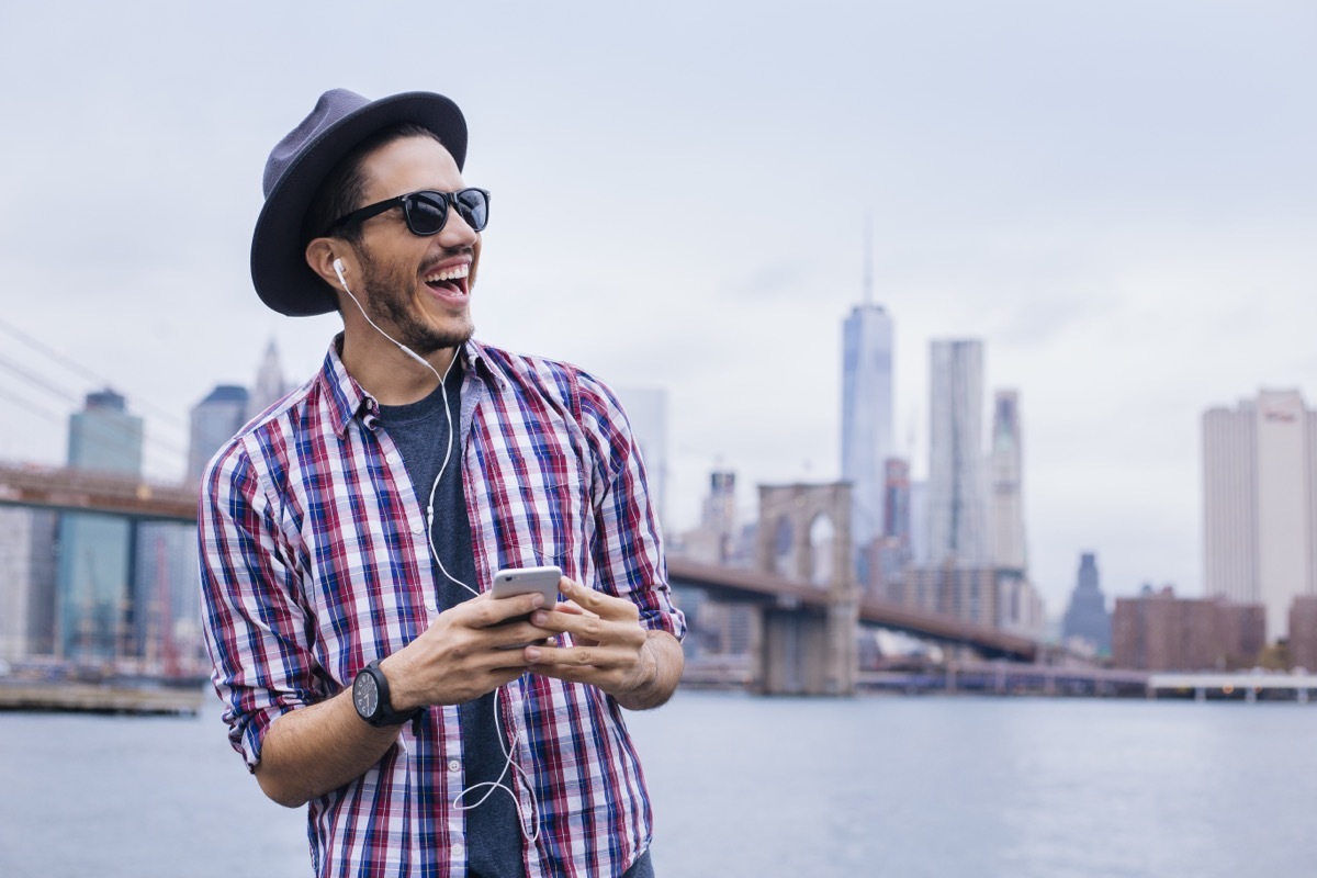 man listening to music on his headphones while enjoying springtime in the city