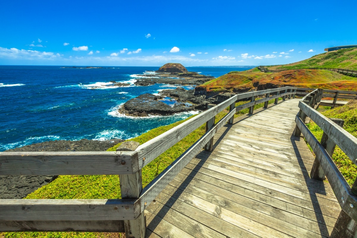 a boardwalk on the side of a coastal cliff overlooking the sea