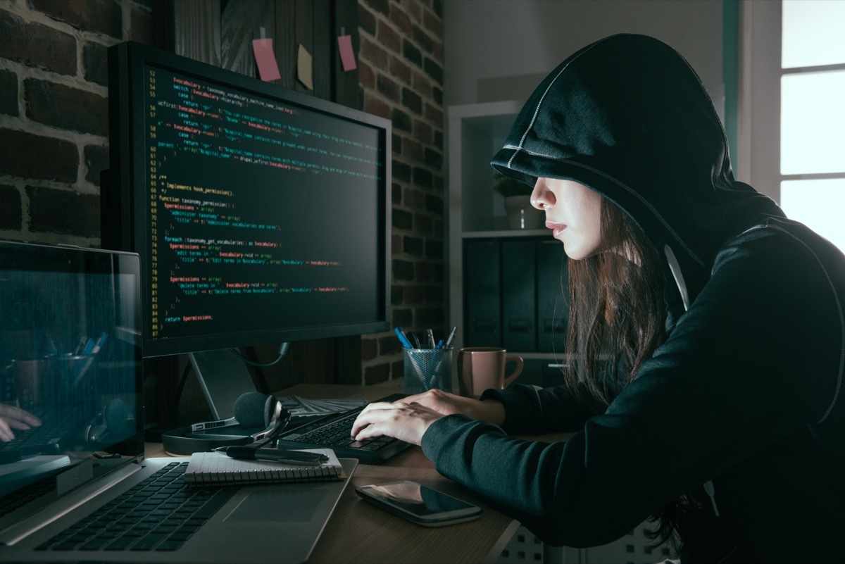 hacker in a hoodie using the computer