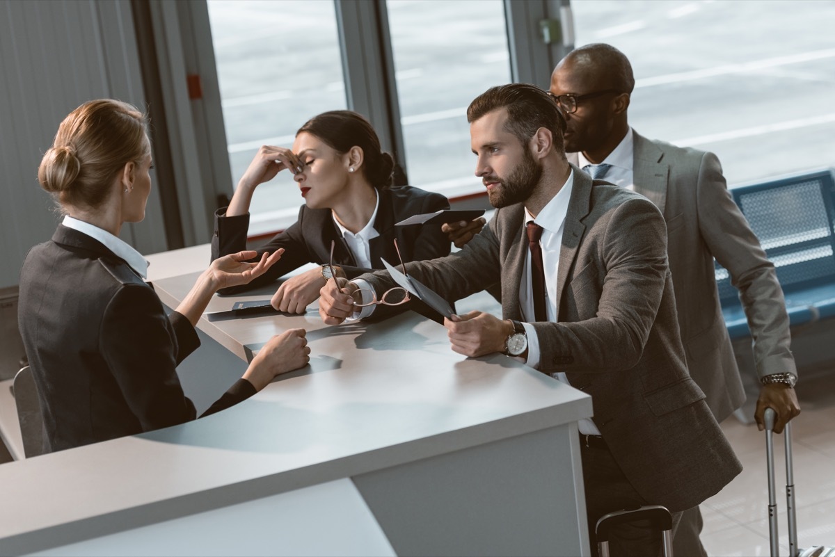 a group of customers yelling at an airport agent, customer service